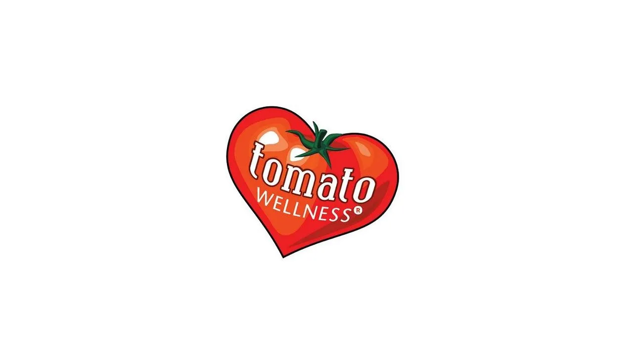 Tomato Wellness logo inside a red heart-shaped tomato on a white background.