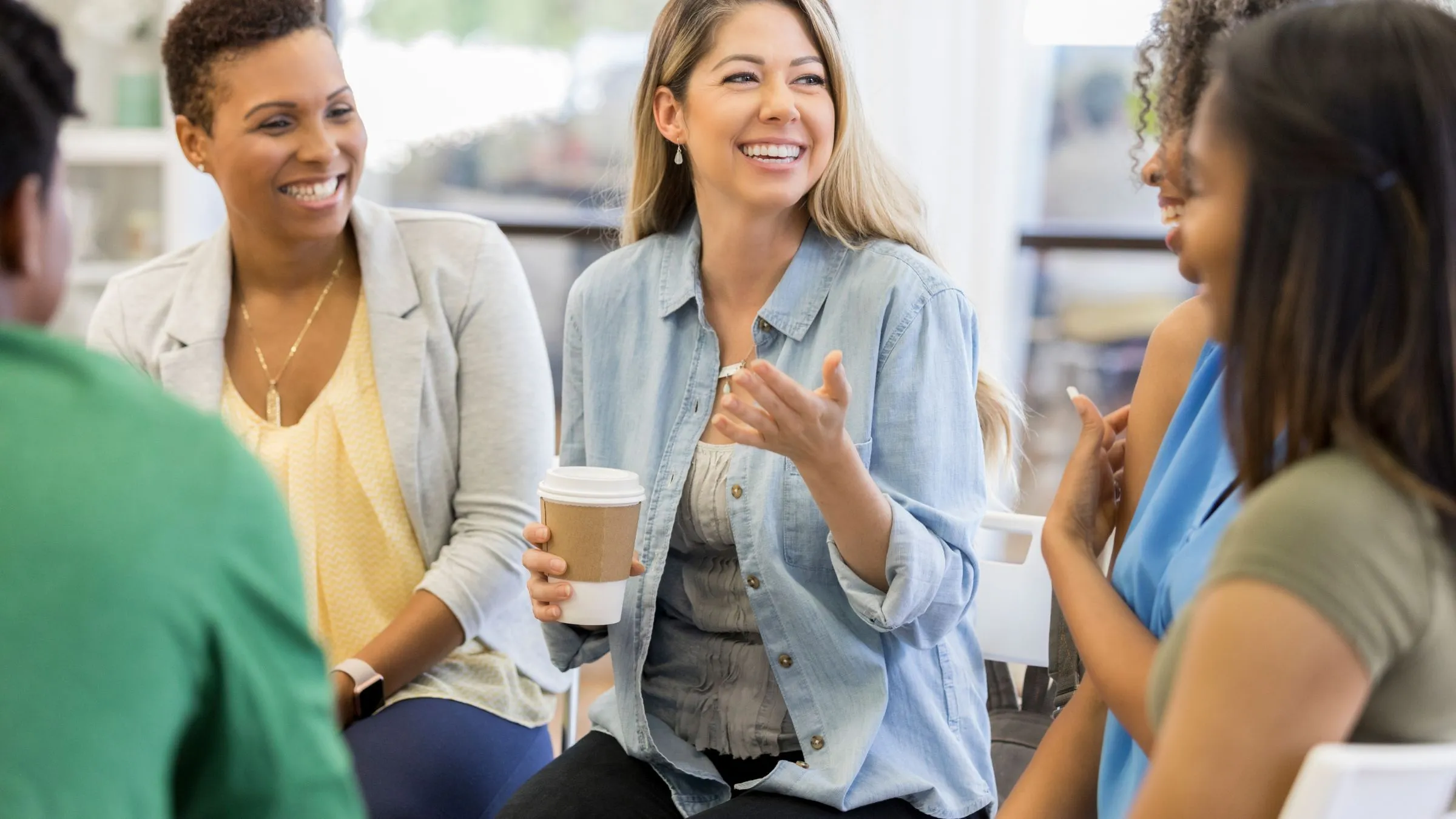 A group of women talking and laughing together.