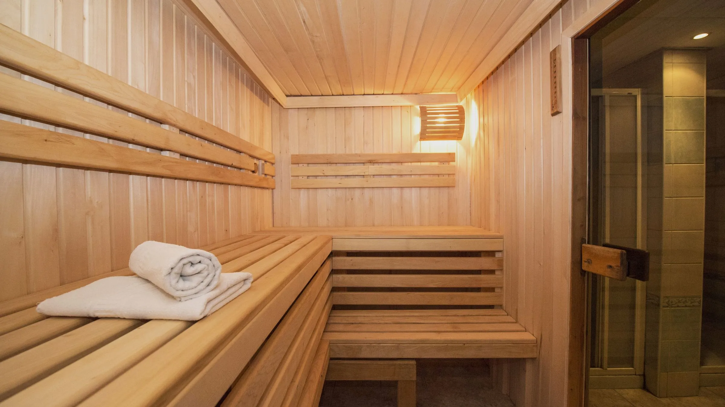 An empty wooden sauna with a folded towel on the bench.