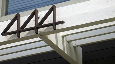 Black house number 444 on a white porch beam.