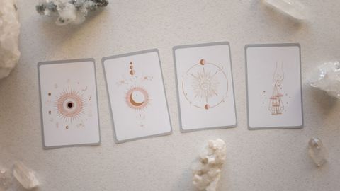 Four pale cards laid in a row among clear quartz crystals.